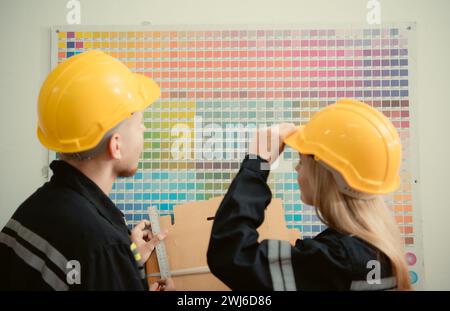 Ouvriers d'entrepôt en uniforme et casques de sécurité travaillant dans une usine de papier Banque D'Images