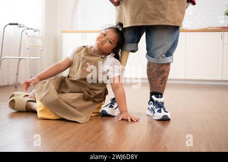 Une famille de grande taille avec un père portant une jambe prothétique, la fille s'est amusée à jouer avec son père avant d'aider à cuisiner. po Banque D'Images