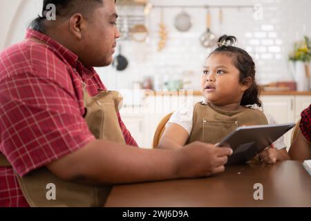 Une grande famille avec un père portant une prothèse de jambe, est heureux d'aider un enfant avec ses devoirs et de s'amuser ensemble Banque D'Images