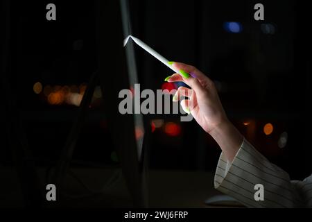 Jeunes courtiers asiatiques négociants internationaux travaillant la nuit au bureau en utilisant l'ordinateur et la pensée. Banque D'Images
