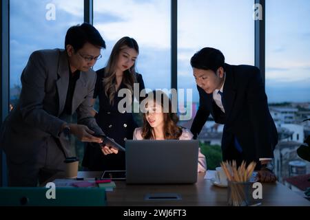 Groupe de courtiers négociants internationaux travaillant activement la nuit au bureau, Une jeune femme travaille Hustle pour présenter un cl Banque D'Images