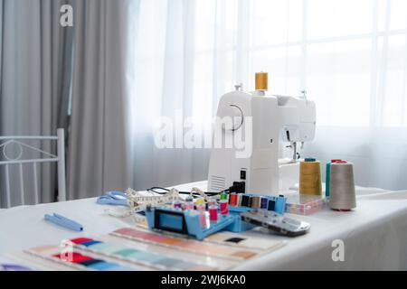 Machine à coudre et accessoires sur la table pour le travail d'un tailleur de robe de mariée Banque D'Images