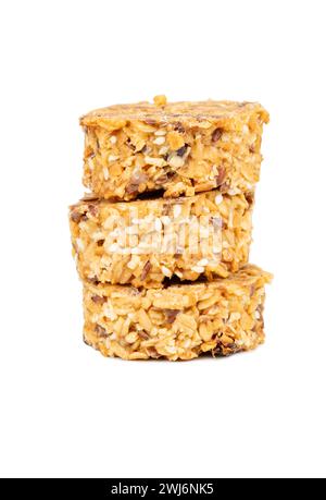 Trois biscuits granola empilés avec des céréales saines et des grains dans le miel isolé sur fond blanc Banque D'Images