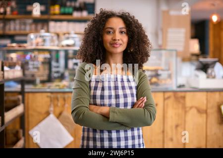 Portrait de jeune femme confiante portant tablier travaillant dans un magasin d'alimentation Banque D'Images