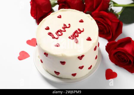 Gâteau Bento avec texte Love You, coeurs en papier et roses sur table blanche. Prog Surprise pour la Saint-Valentin Banque D'Images