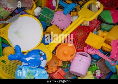 Vue de jouets de plage en plastique coloré dans une boîte à jouets en bois peint Banque D'Images