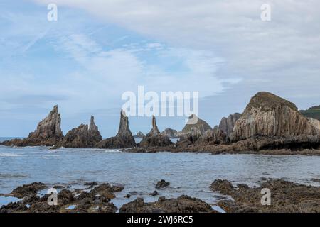 vue panoramique sur les formations rocheuses déchiquetées au milieu de la mer, sous un ciel avec des nuages sinueux, exsudant la tranquillité et la beauté naturelle Banque D'Images