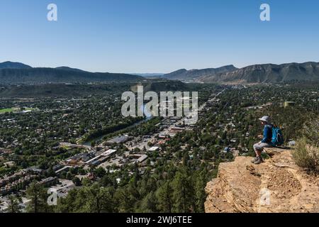 FEMME RANDONNEUR ASSIS SUR LE REBORD AU-DESSUS DE DURANGO, COLORADO, USA Banque D'Images