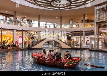 Les visiteurs appréciant les promenades EN SAMPAN longent le canal au Shoppes at Marina Bay Sands. Banque D'Images