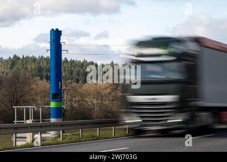 LKW-Mauterfassung auf der Landstraße B8 BEI Selters 13.02.24, Selters : Symbolfoto, Illustrationsbild, Symbolbild, Illustrationsfoto LKW-Mauterfassung auf der Landstraße B8 BEI Selters Auf dem Bild ist eine blaue Stehle zur Erfassung der LKW-Maut auf der Landstraße B8 in der Nähe von Selters zu sehen. Ein LKW fährt gerade an der Mautstelle vorbei, was den Prozess der automatischen Gebührenerfassung für Nutzfahrzeuge auf deutschen Straßen illustriert Selters Hessen Allemagne *** péage camion sur l'autoroute B8 près de Selters 13 02 24, Selters photo symbole, image illustration, image symbole, i Banque D'Images