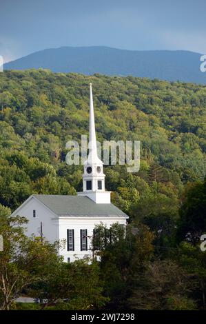 Un grand clocher blanc d'une église est joué contre une forêt vallonnée dans une petite ville du Vermont, en Nouvelle-Angleterre Banque D'Images