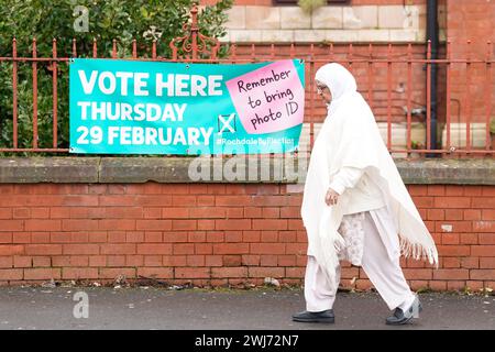 Une femme passe devant un panneau pour un bureau de vote à Rochdale, Greater Manchester, avant l'élection partielle de jeudi. Le Parti travailliste a retiré son soutien au candidat à l'élection partielle Azhar Ali, après avoir critiqué les remarques qu'il a faites à propos d'Israël. M. Ali s'était excusé après qu'il ait été enregistré comme suggérant lors d'une réunion du Parti travailliste du Lancashire qu'Israël avait pris l'assaut du Hamas du 7 octobre comme prétexte pour envahir Gaza. Date de la photo : mardi 13 février 2024. Banque D'Images