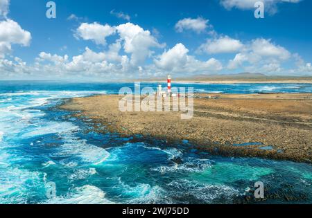 Embrassez l'esprit maritime à Faro de Tostón, Fuerteventura, où le phare emblématique monte la garde sur les eaux Azur et les côtes accidentées. Banque D'Images
