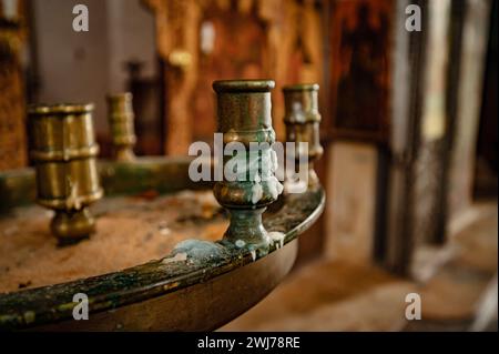 Bougeoirs en métal exposés sur une table en bois rustique dans un espace intérieur bien éclairé Banque D'Images