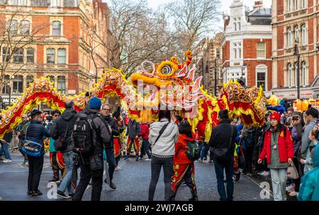 Londres. UK- 02.11.2024. Un groupe exécutant une danse du dragon dans la parade de célébration du nouvel an chinois avec une grande foule le long de la rue. Banque D'Images