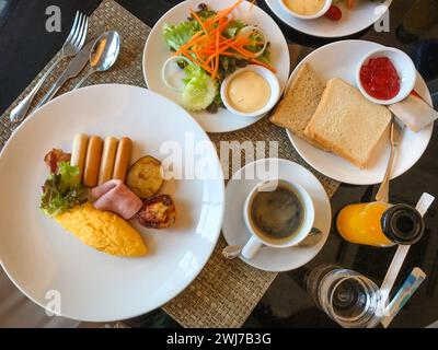 Table pleine de divers aliments frais dans le restaurant moderne de luxe. Plats délicieux, charcuterie, saumon, omelette, viennoiseries, jus, fromage. Délicieux et l Banque D'Images