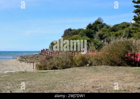 Marbella, Espagne - 8 décembre 2023 : les gens à la passerelle piétonne en bois du littoral à Marbella, Malaga, Espagne. Banque D'Images