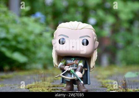 Funko Pop figurine d'Elf Legolas du film fantastique le Seigneur des anneaux. Guerrier tenant un arc et une flèche. Feuilles vertes, mousse, chemin de pierre. Banque D'Images