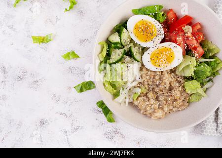 Petit déjeuner porridge d'avoine avec œufs durs, tomate, concombre et oignons. Alimentation saine et équilibrée. Cuisine tendance. Vue de dessus, pose à plat Banque D'Images