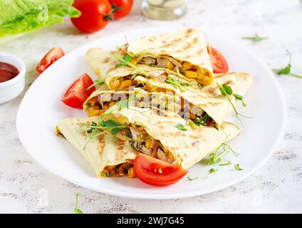 Emballage Quesadilla mexicain avec poulet, maïs et poivron sur assiette blanche. Banque D'Images