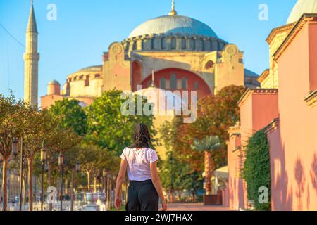 Femme musulmane dans le hijab traditionnel s'émerveille devant un panorama incroyable du passé d'Istanbul depuis la Grande Mosquée Sainte-Sophie. Splendide édifice, érigé par Banque D'Images