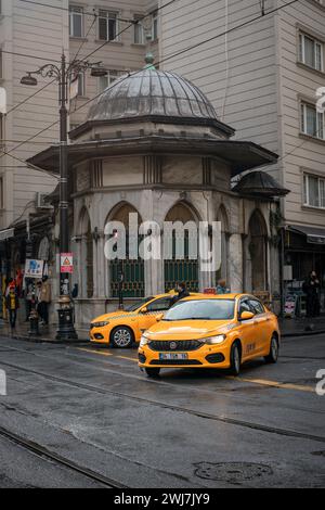 Navigation sous la pluie : les taxis illuminent les rues pavées d'Istanbul Banque D'Images