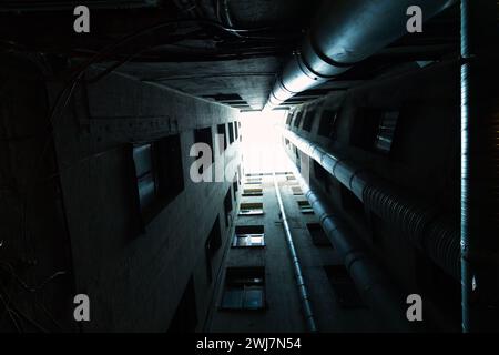 Perspective de cour intérieure sombre, fond architectural abstrait. Photo tonique prise dans le vieux quartier de Saint-Pétersbourg, Russie Banque D'Images