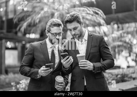 collègues professionnels avec rapports de stock par téléphone en combinaison. photo de collègues Banque D'Images