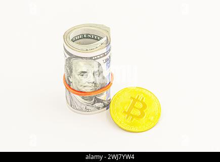 bitcoin BTC coin et rouleau de billets de banque de billets de dollar fond blanc. Billets de dollar américain en rouleaux avec Bitcoin en argent. Banque D'Images