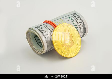 bitcoin BTC coin et rouleau de billets de banque de billets de dollar fond blanc. Billets de dollar américain en rouleaux avec Bitcoin en argent. Banque D'Images