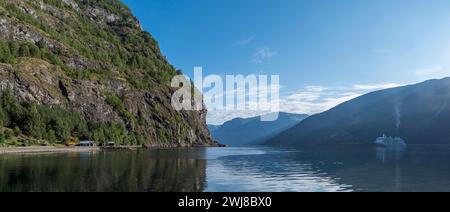 Vue panoramique matinale des rayons du soleil sur l'Aurlandsfjord vu du bord de l'eau à Flåm, Norvège. Banque D'Images
