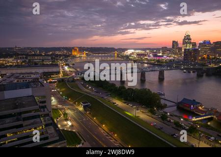 Quartier du centre-ville de Cincinnati ville dans l'Ohio, États-Unis la nuit avec la circulation des voitures sur le pont et brillamment illuminé de hauts gratte-ciel Banque D'Images