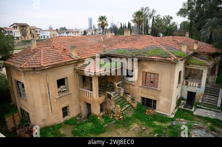 Nikosia, Chypre. 12 février 2024. Une maison abandonnée et délabrée se trouve à l'intérieur de la soi-disant «ligne verte» à Nicosie. La partie nord turque de Nicosie peut être vue en arrière-plan. La «ligne verte» est la zone tampon démilitarisée entre Chypre du Nord occupée par la Turquie et la République de Chypre, qui est surveillée par les Nations Unies (ONU). Crédit : Bernd von Jutrczenka/dpa/Alamy Live News Banque D'Images