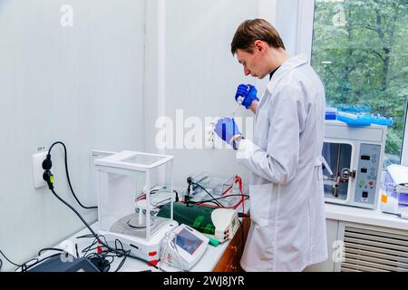 Scientifique avec la main gantée plaçant l'échantillon d'ADN dans PCR-cycler en temps réel. Banque D'Images