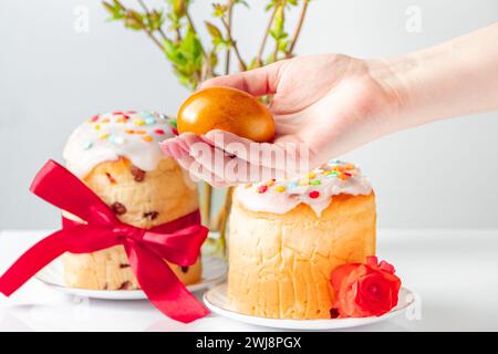 La main tient l'œuf de Pâques brillant. Symbole du printemps et de bonnes vacances. Banque D'Images