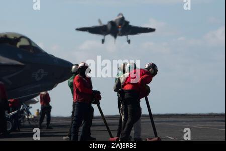 240122-N-PQ495-1057 MER DE CHINE MÉRIDIONALE (22 janvier 2024) des marins attendent un F-35C Lightning II, affecté aux « Warhawks » du Strike Fighter Squadron (VFA) 97, pour récupérer sur le pont d’envol du porte-avions de classe Nimitz USS Carl Vinson (CVN 70). Vinson, navire amiral du Carrier Strike Group ONE, est déployé dans la zone d'opérations de la 7e flotte américaine à l'appui d'un Indo-Pacifique libre et ouvert. (Photo de l'US Navy par Larissa T. Dougherty, spécialiste des communications de masse, 2e classe) Banque D'Images