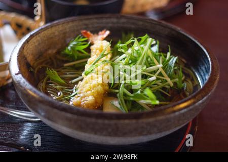 Gros plan d'un bol de délicieux thé vert tempura de crevettes soba (nouilles japonaises) servi avec des légumes frais, Nara, Japon Banque D'Images