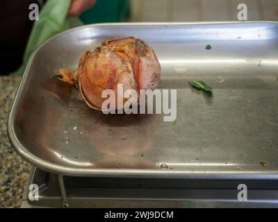 le vendeur de femme senior pèse gros oignon rose organique dans une balance à l'image haute résolution de magasin de détail Banque D'Images