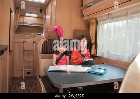 Vacances en famille, voyage de vacances en camping-car, camping, voyage heureux des enfants souriants en camping-car, enfants dans l'intérieur du camping-car Banque D'Images