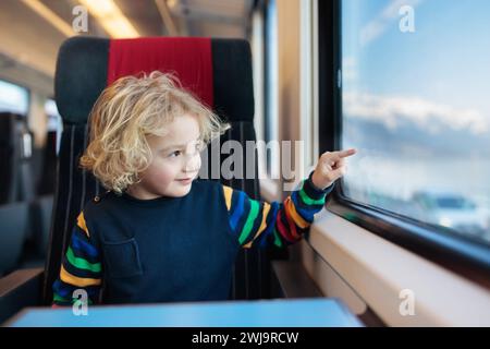 Enfant voyageant en train. Petit enfant dans un train express à grande vitesse en vacances en famille en Europe. Voyagez en train. Les enfants en wagon de chemin de fer. Banque D'Images