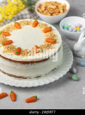 Gâteau aux carottes de Pâques fait maison avec des noix, glacé avec du fromage à la crème. Dessert sucré. Assiette avec délicieux gâteau aux carottes Banque D'Images