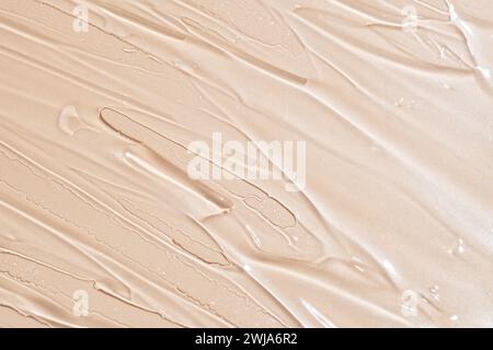 Image de haute qualité mettant en valeur la texture lisse d'un frottis de maquillage de fond de teint beige crémeux Banque D'Images