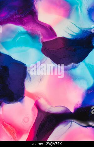 Un fond abstrait et coloré d'encre tourbillonnant dans l'eau avec des nuances de rose, bleu et noir Banque D'Images
