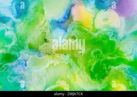 Une image abstraite enchanteresse mettant en valeur un motif artistique fluide avec des teintes tourbillonnantes de vert, bleu et jaune, créant une texture visuelle rêveuse Banque D'Images