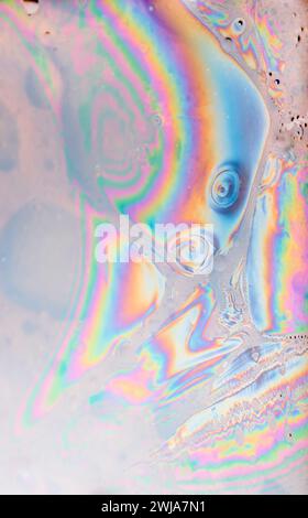 Une photo en gros plan d'un mélange d'huile et d'eau créant un motif psychédélique avec des couleurs arc-en-ciel Banque D'Images