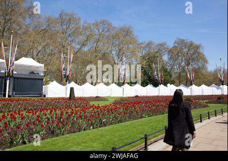 Les gens passent devant des tentes installées près du palais de Buckingham alors que Londres se prépare au couronnement du roi Charles III Banque D'Images