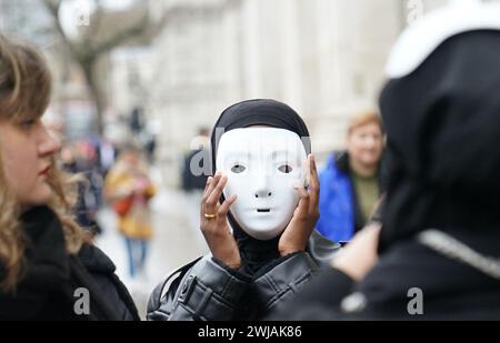 Des manifestants d'Amnesty International, vêtus de noir et portant des masques blancs, et tenant des déclarations de Palestiniens à Rafah, prennent part à une veillée silencieuse pour la Palestine devant les portes de Downing Street, dans le centre de Londres. Date de la photo : mercredi 14 février 2024. Banque D'Images