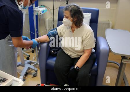 Infirmière utilisant un brassard de pression artérielle sur un patient avant d'administrer une perfusion de fer à l'hôpital Surrey Angleterre Banque D'Images