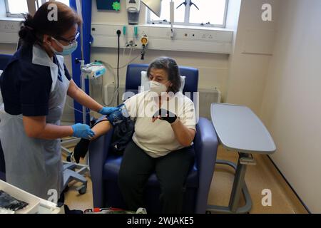 Infirmière utilisant un brassard de pression artérielle sur un patient avant d'administrer une perfusion de fer à l'hôpital Surrey Angleterre Banque D'Images