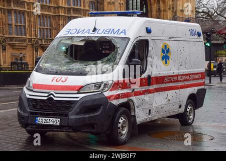 Londres, Royaume-Uni. 14 février 2024. Une ambulance criblée de trous de balles a été exposée devant le Parlement britannique avec d'autres objets appartenant à des ambulanciers paramédicaux, à l'approche du deuxième anniversaire de l'invasion russe de l'Ukraine. Crédit : Vuk Valcic/Alamy Live News Banque D'Images